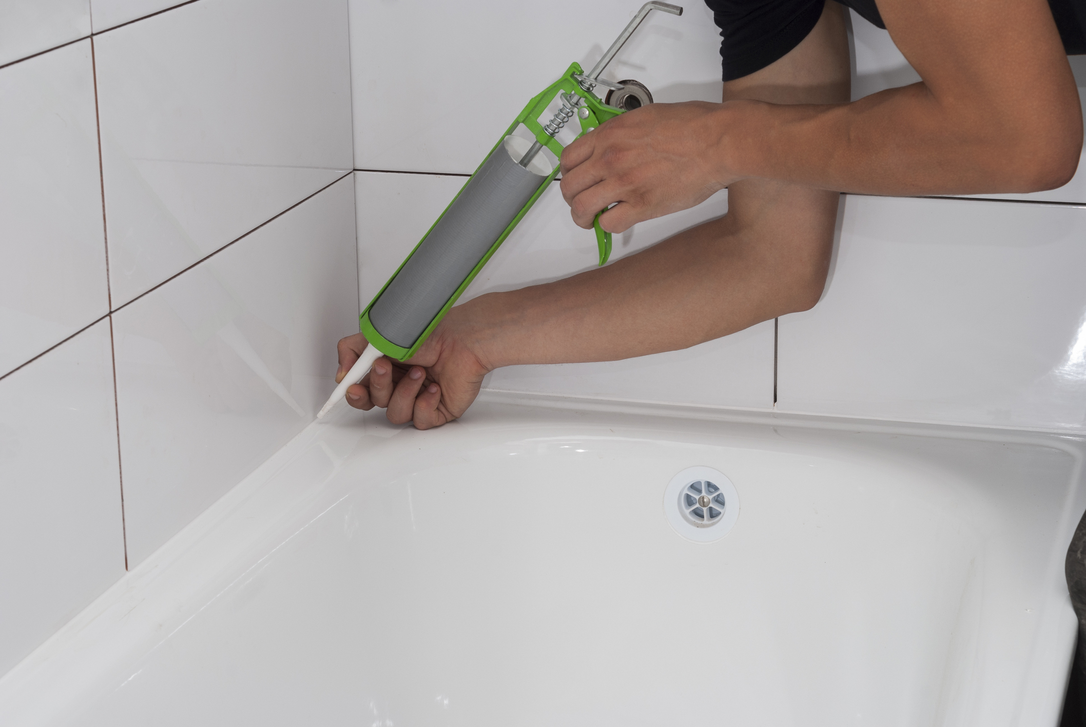 plumber apply silicone sealant to the joint bathtubs and ceramic tile